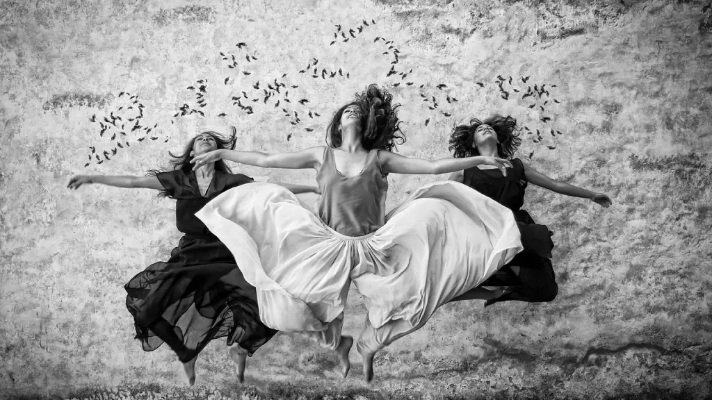 foto en blanco y negro donde aparecen tres mujeres recostadas sobre la arena. 
