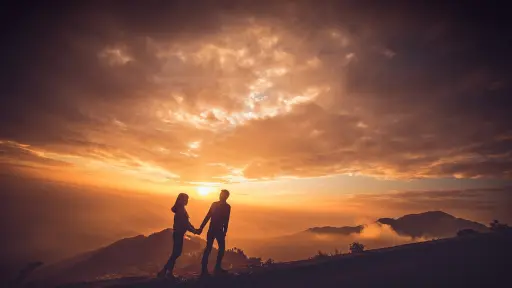 Una pareja de la mano en un atardecer